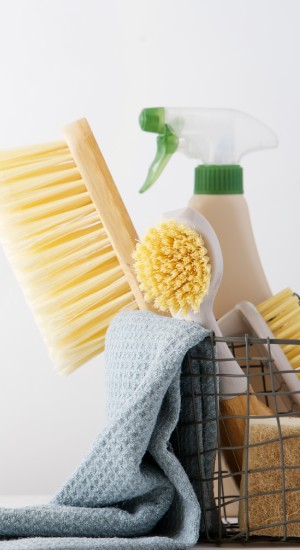 Eco brushes, sponges and rag in cleaning basket. Cleaner concept on white background